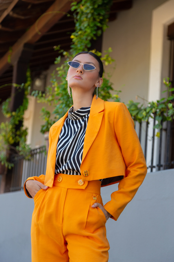 Woman in Sunglasses Posing in Orange Suit